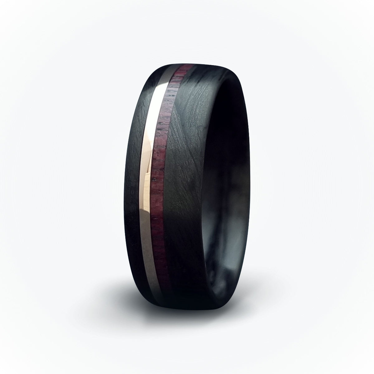 A men's carbon fiber ring with a double inlay of gold and purple heart wood, featuring a black band and a purple heart-wood inlay.