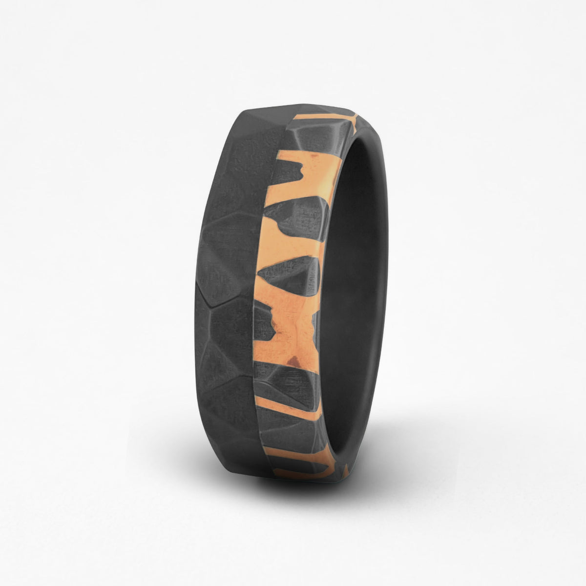 Black and copper patterned ring on a white background