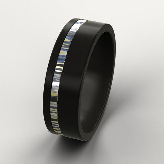 Black ring with a colourful patterned metal inlay on a light grey background