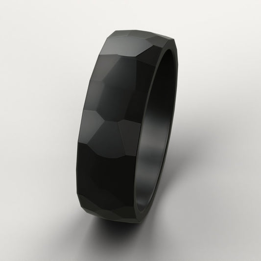 Black faceted ring on a light gray background
